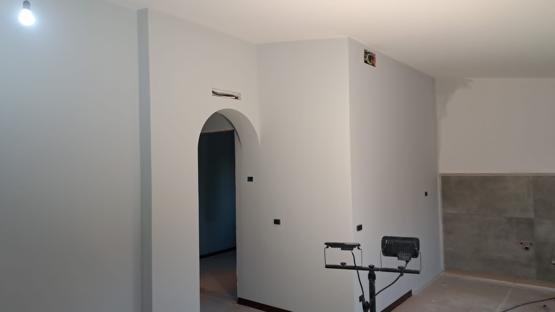 Una stanza con pareti bianche e una luce sul soffitto.