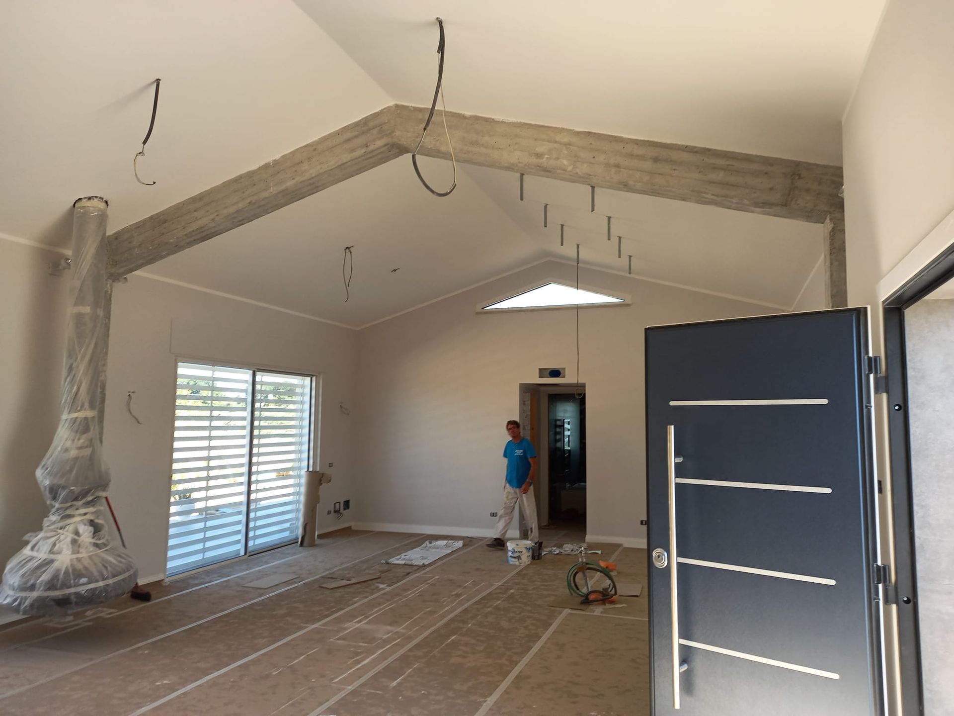 Un uomo è in piedi in una stanza vuota con una porta nera.