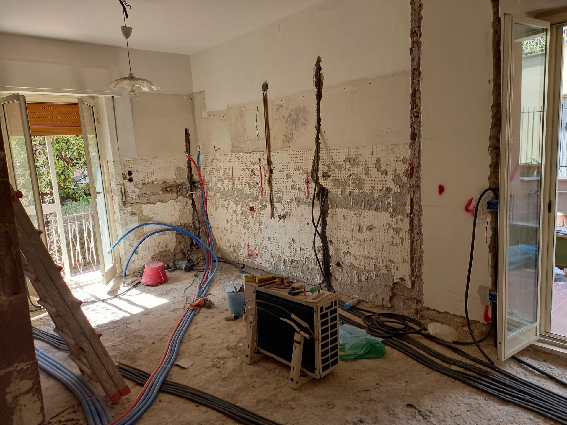 Una stanza in costruzione con una scala e una scatola sul pavimento.