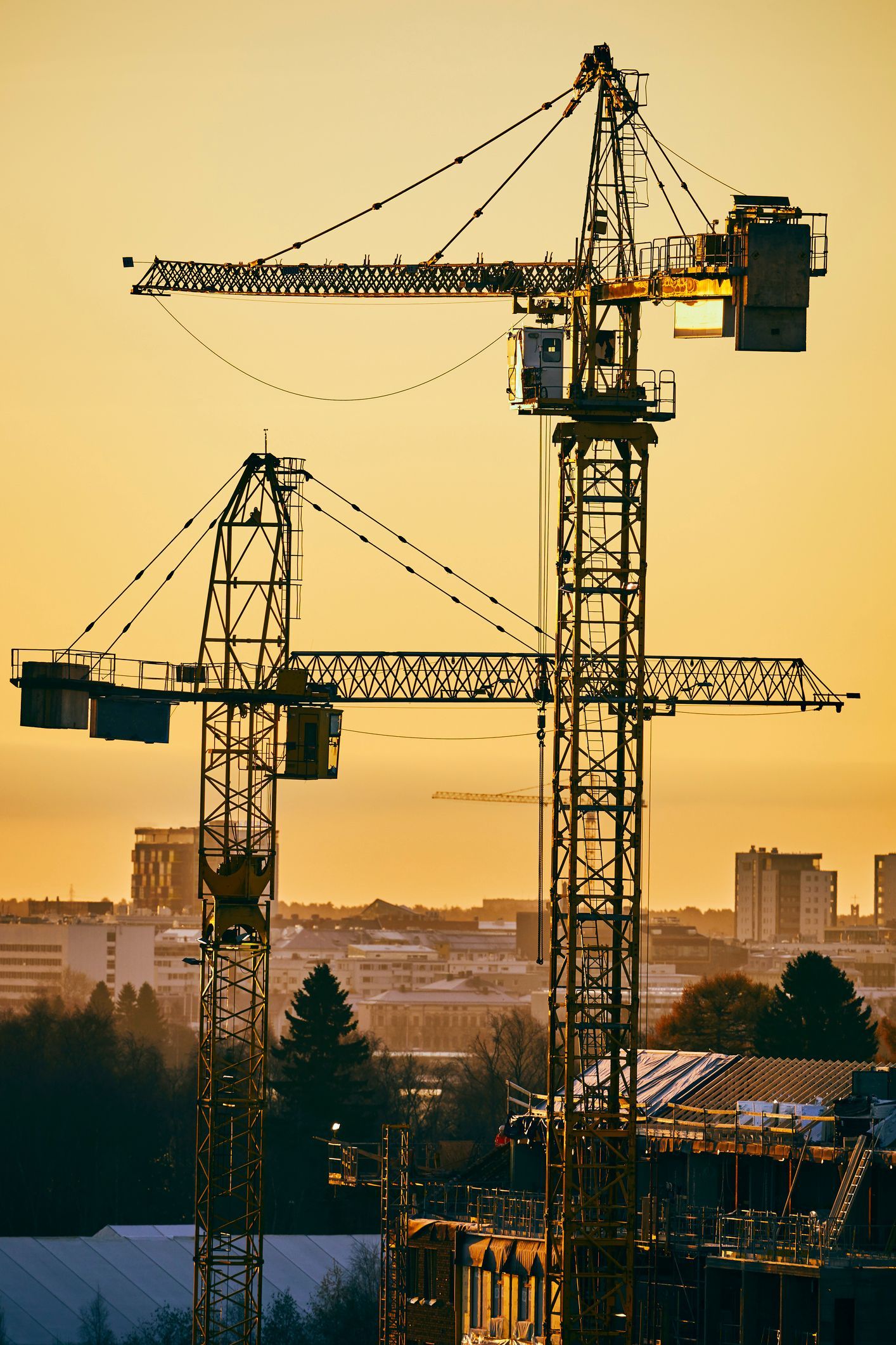 Due gru edili sono posizionate sopra un edificio in costruzione.