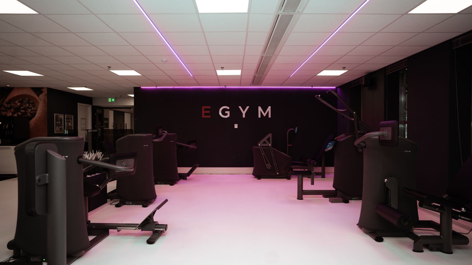 Een man tilt halters op een bankje in een sportschool.