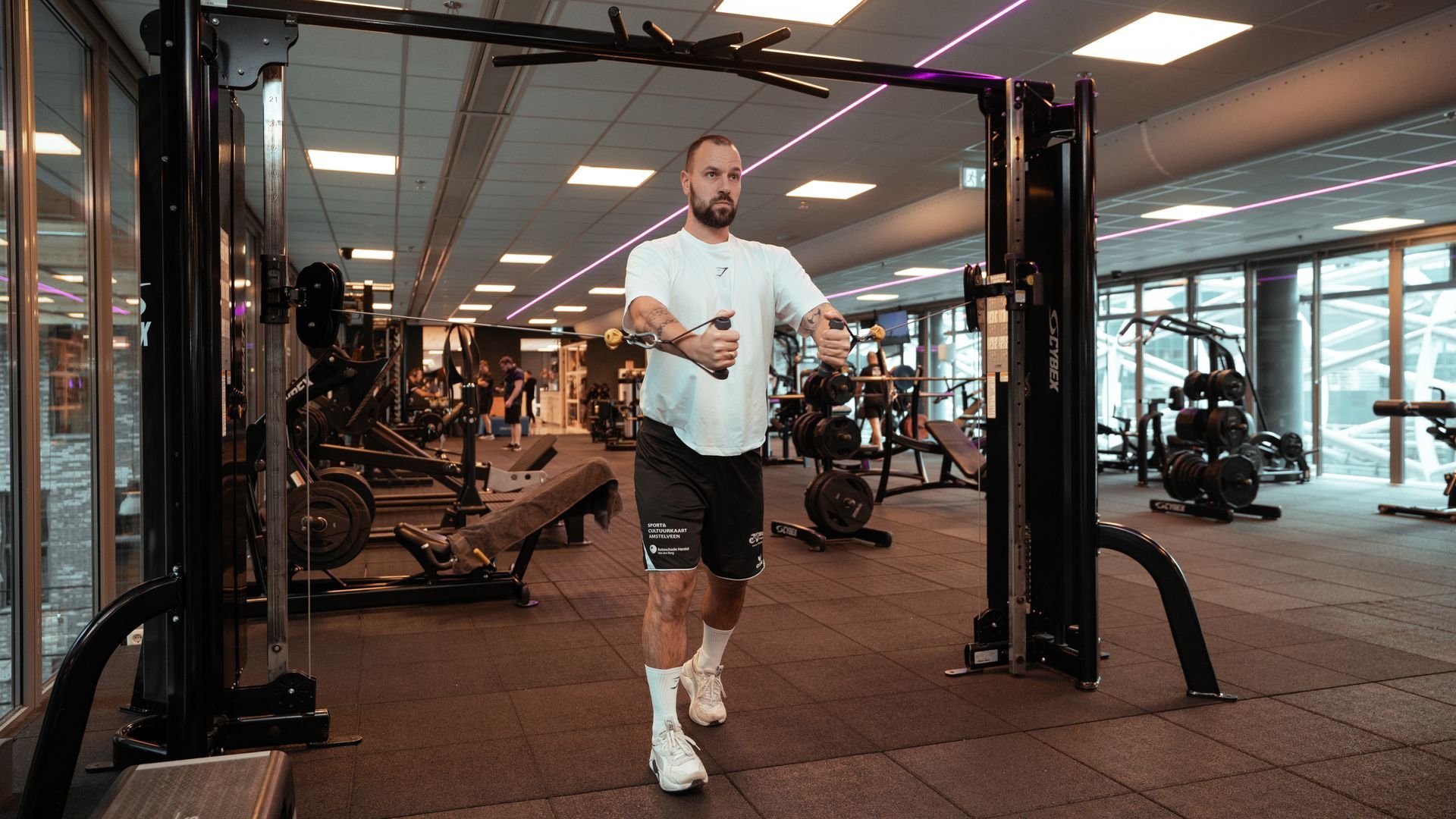 Een groep mensen doet pilatesoefeningen in een sportschool.