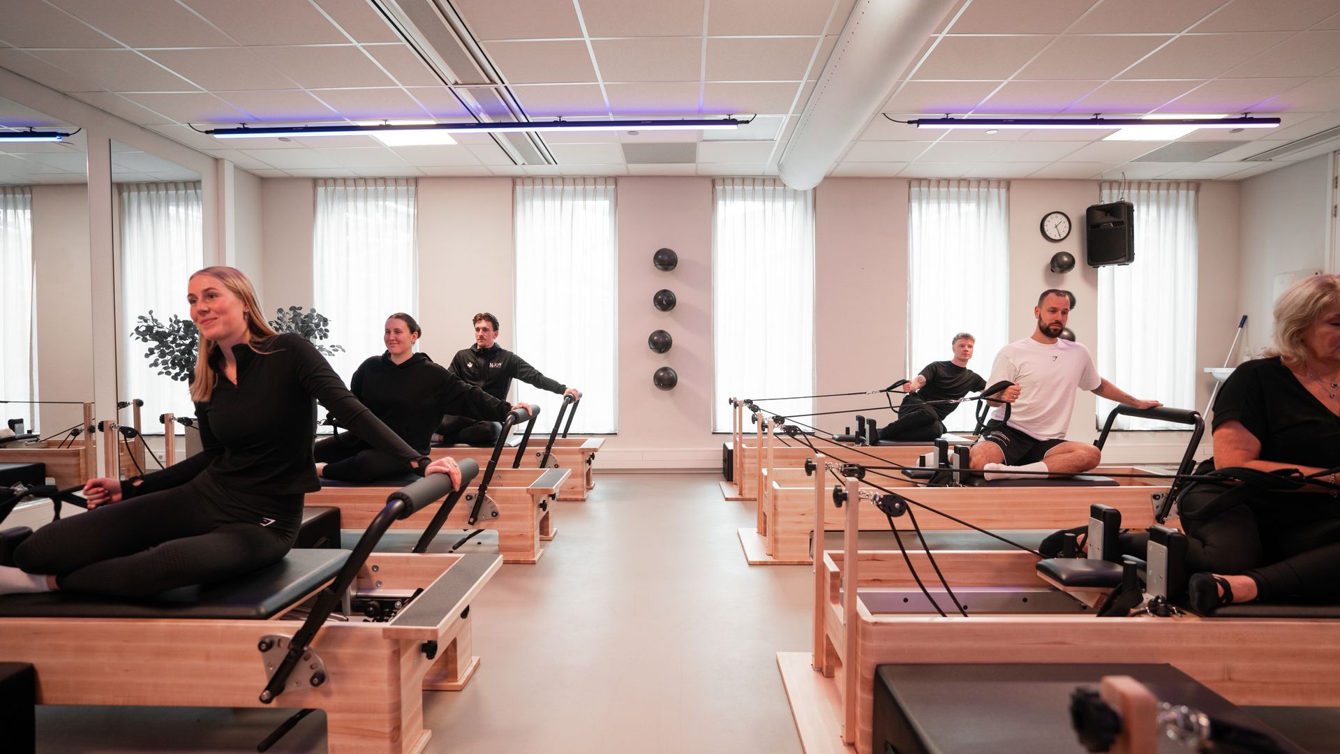 Een vrouw zit aan een bureau voor een computer en praat met een man.