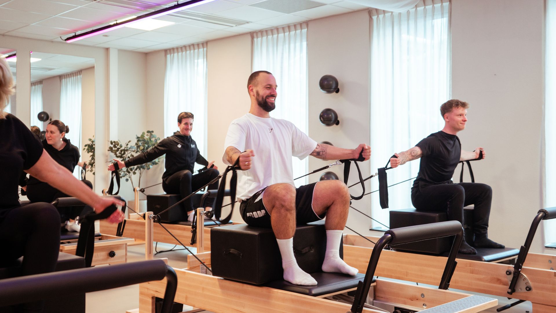Een man fietst op een hometrainer in een sportschool.
