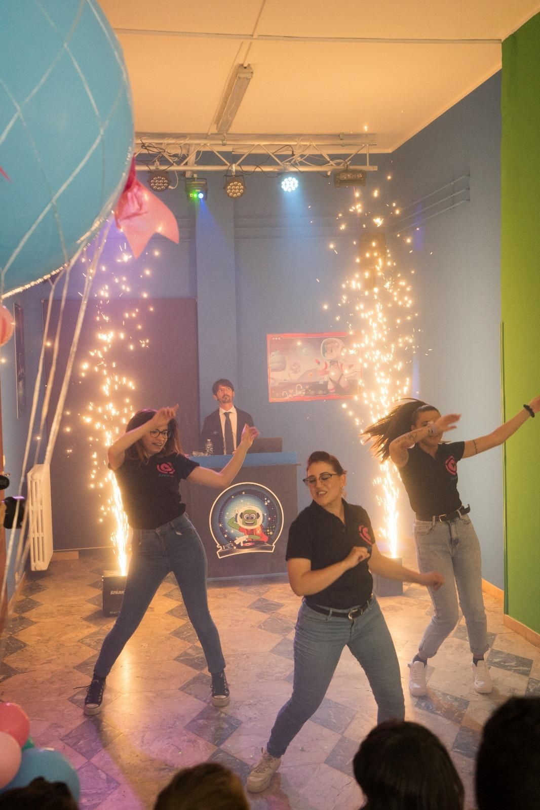 Un gruppo di donne balla davanti a un dj durante una festa.