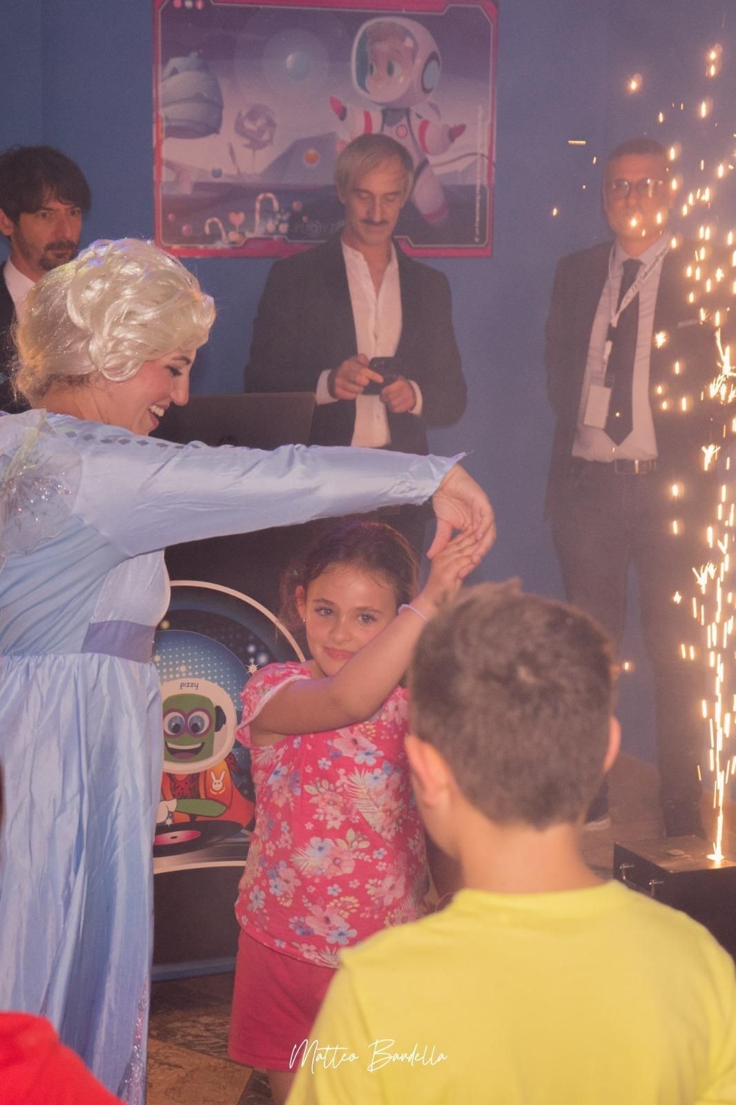 Una donna vestita da elsa di Frozen balla con una bambina.