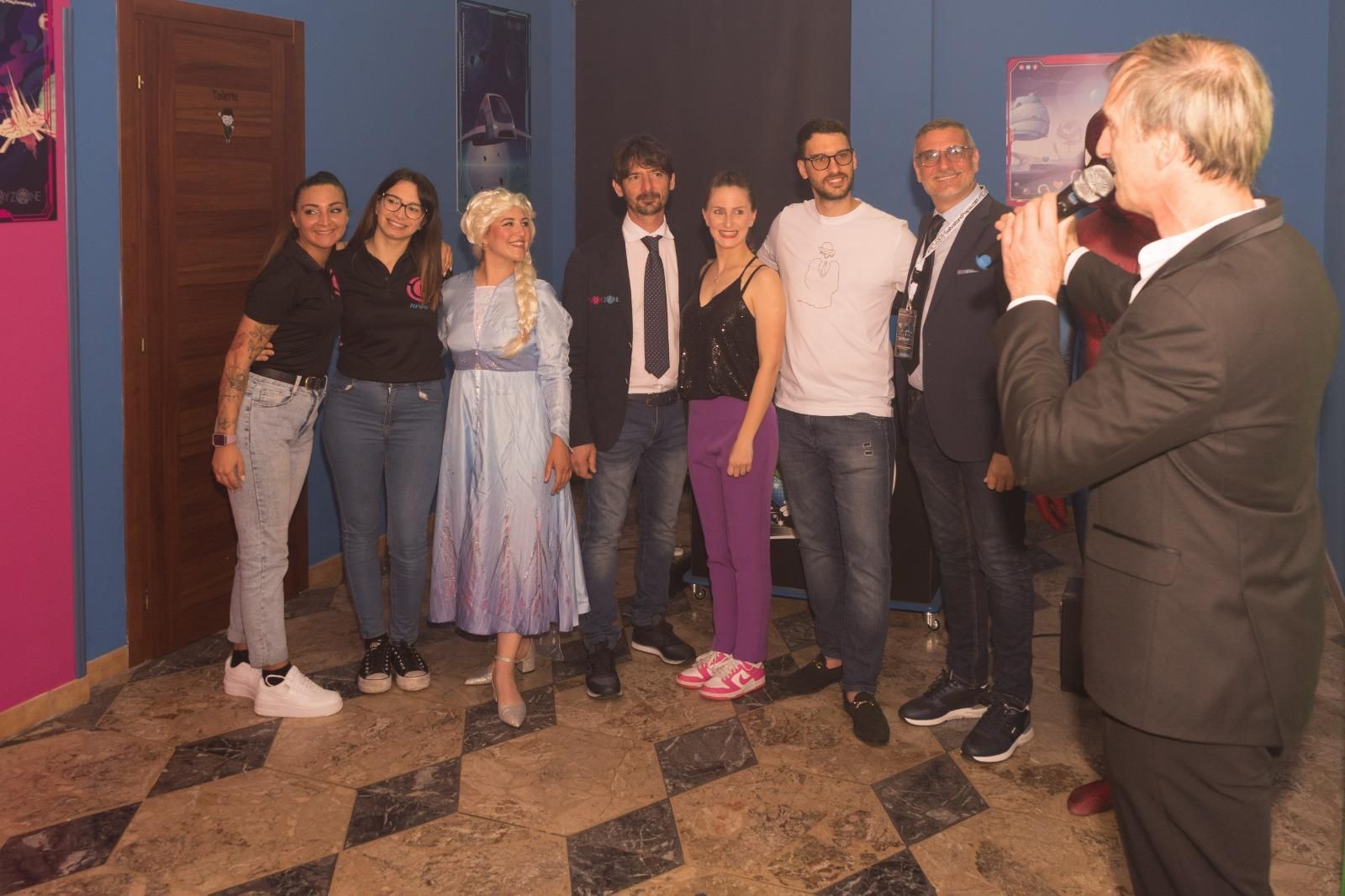 Un uomo sta scattando una foto di un gruppo di persone in piedi una accanto all'altra.