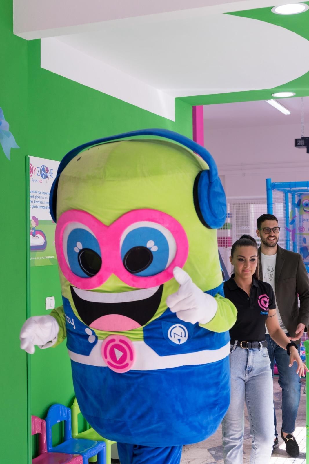 Una mascotte indossa le cuffie e dà il pollice in alto.