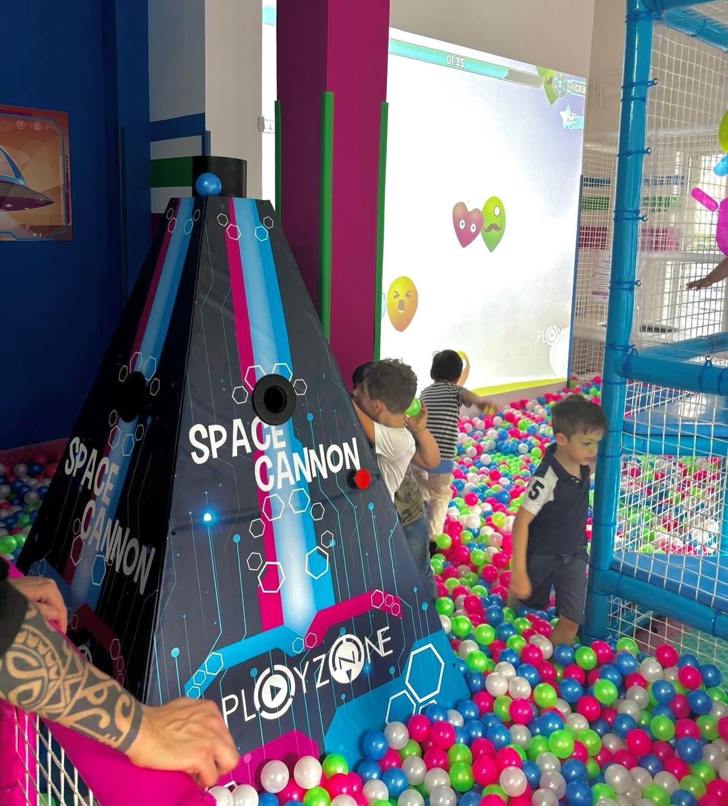 I bambini giocano in una vasca con palline che dice cannone spaziale