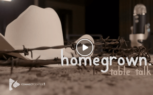 A cowboy hat and barbed wire are on a table next to a microphone.