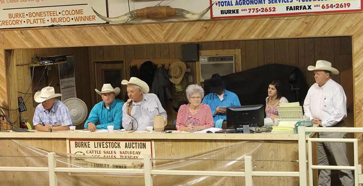 A group of people in cowboy hats are sitting at a table.