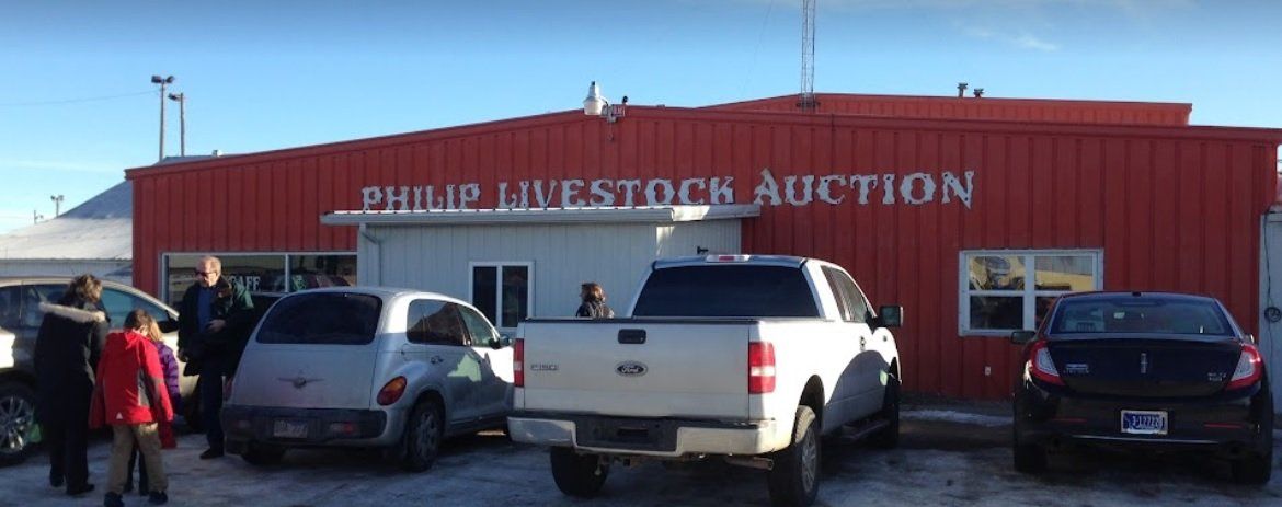 A red building with a lot of cars parked in front of it.