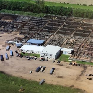 An aerial view of a large warehouse with a white building in the middle