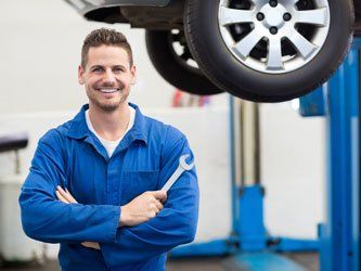 Mechanic smiling while holding tool - Auto Mechanic in Edinburgh, IN