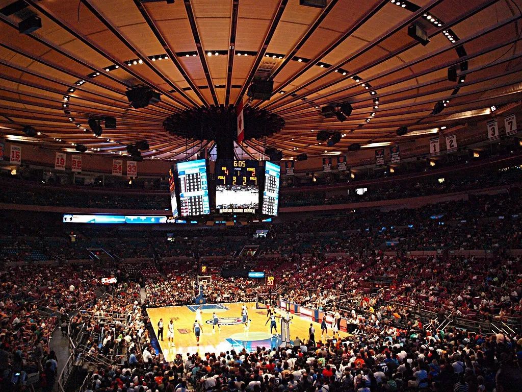 A basketball game is being played in a large stadium