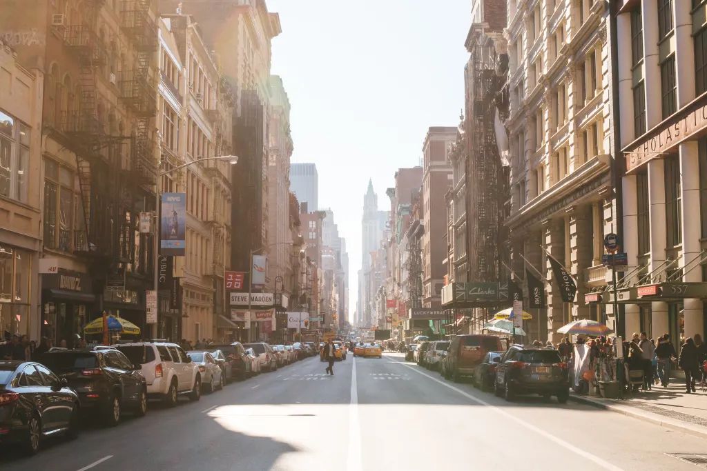 A city street with a lot of cars parked on the side of it.