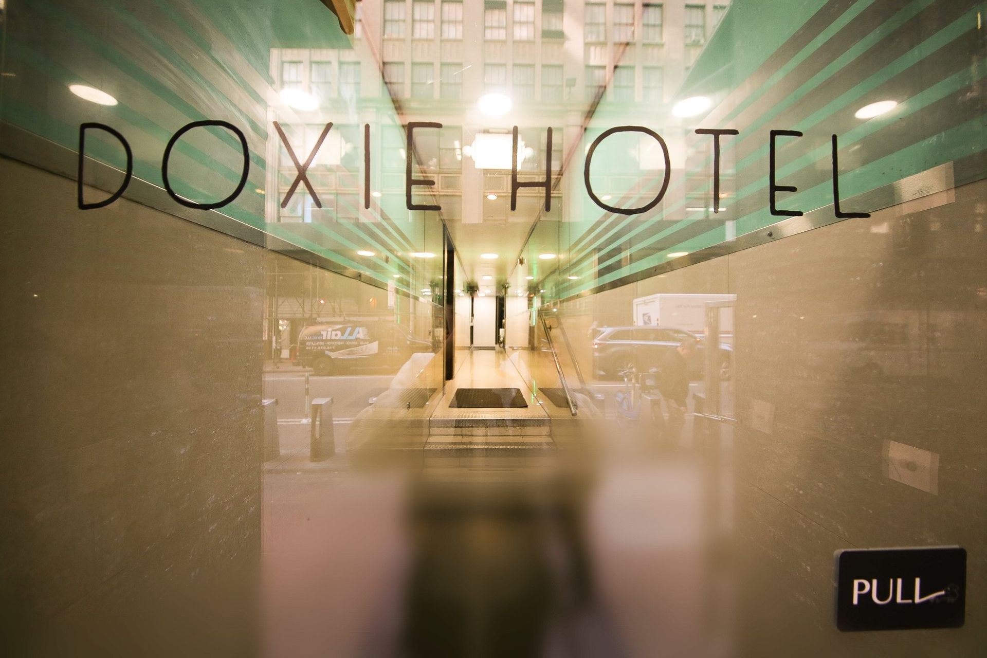 A glass door with the words doxie hotel written on it