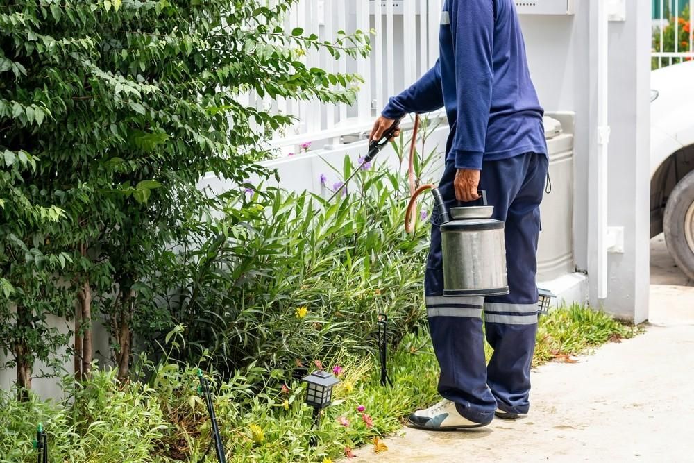 Person in Blue Suit Sprays Plants in A Garden — My Habitat Products in Cooktown, QLD
