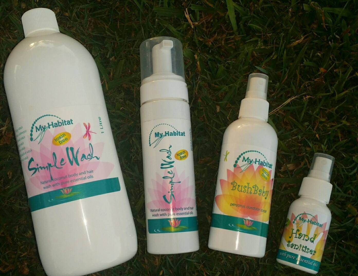 Four White Bottles of My Habits Skincare Products on Green Grass — My Habitat Products in Malanda, QLD