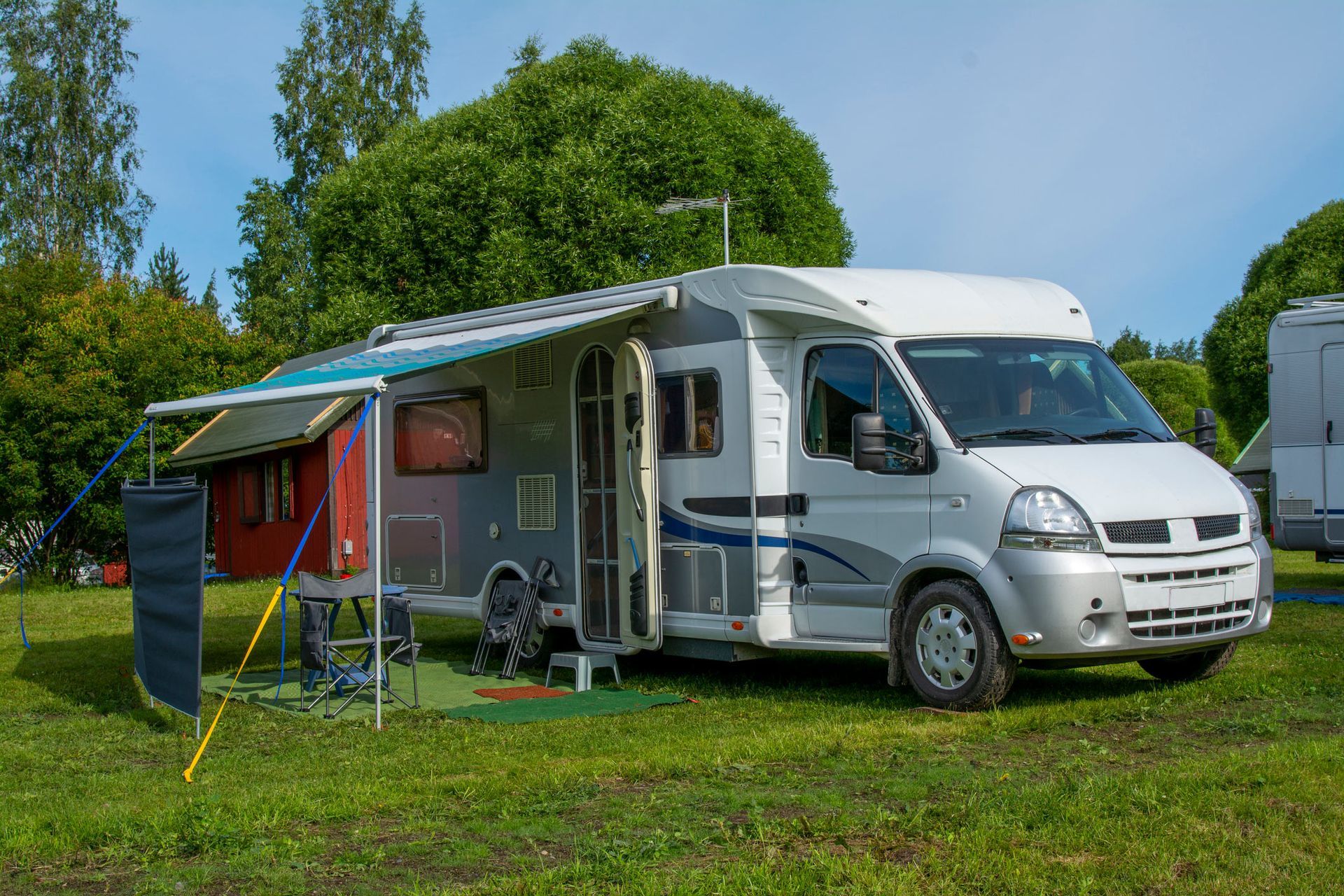 A camper van is parked in a grassy field.