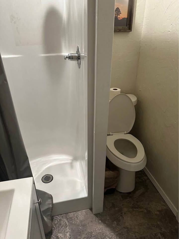 A bathroom with a toilet and a shower stall.