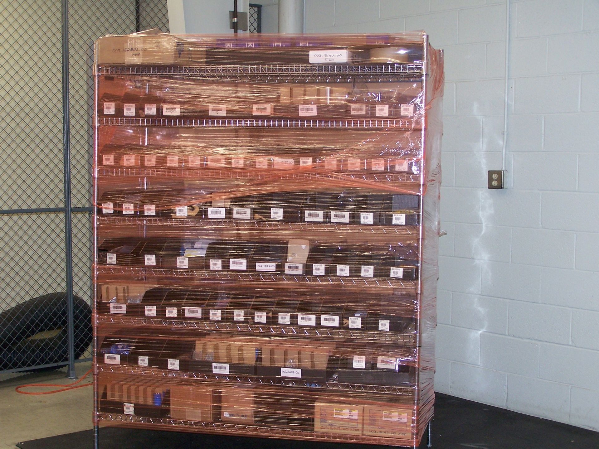 A copper shelving unit with boxes on it in a room