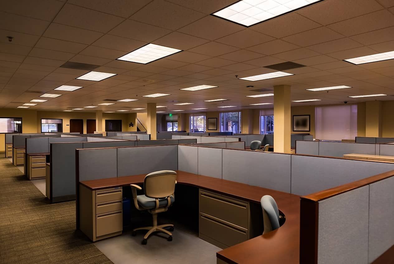 A large office with cubicles and desks and chairs