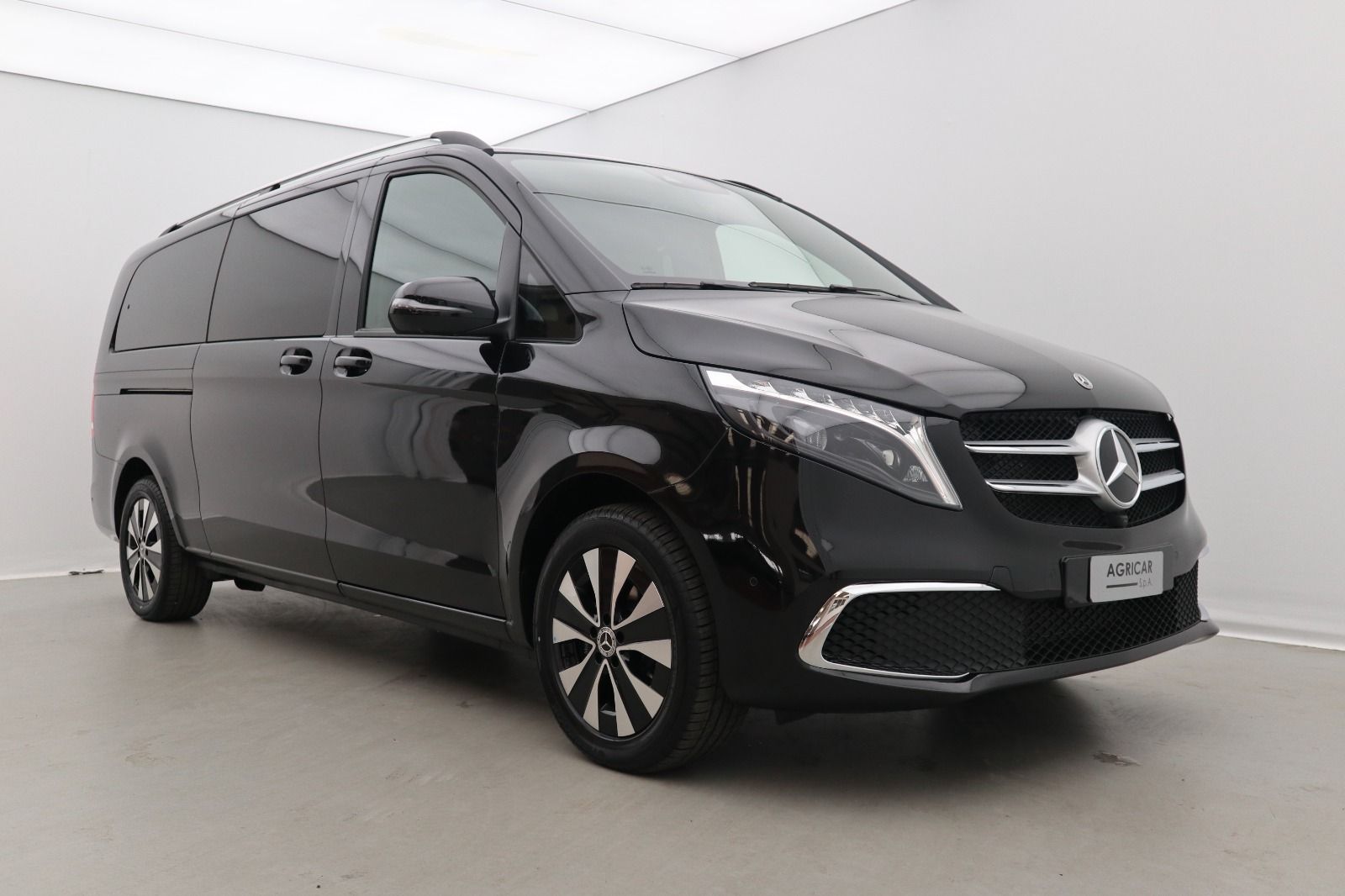 Un furgone Mercedes nero è parcheggiato in uno showroom.