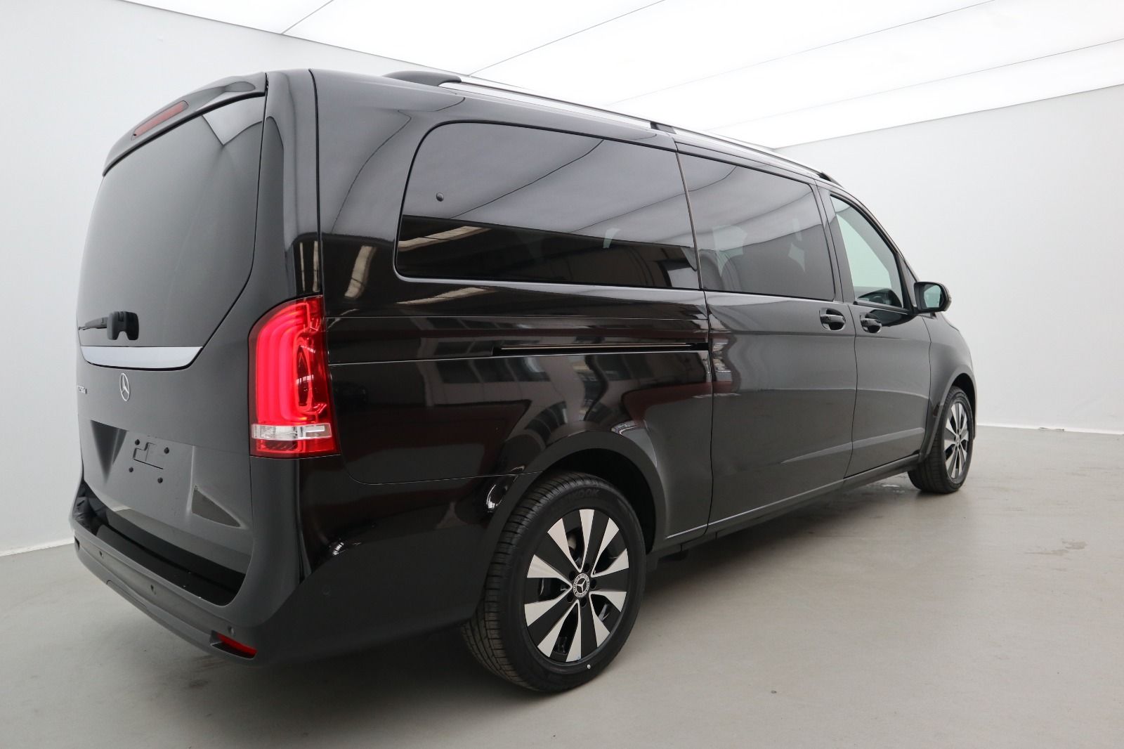 Un furgone nero è parcheggiato in una stanza con una parete bianca.