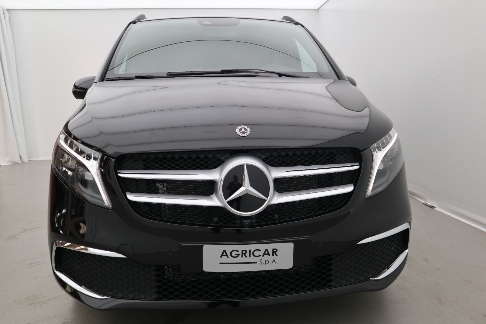 Un furgone mercedes benz nero è parcheggiato in un garage.