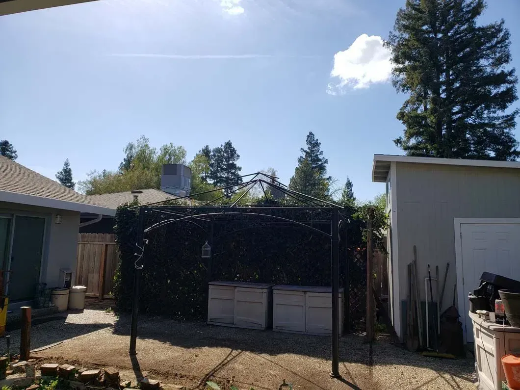 A backyard with a gazebo and a shed.