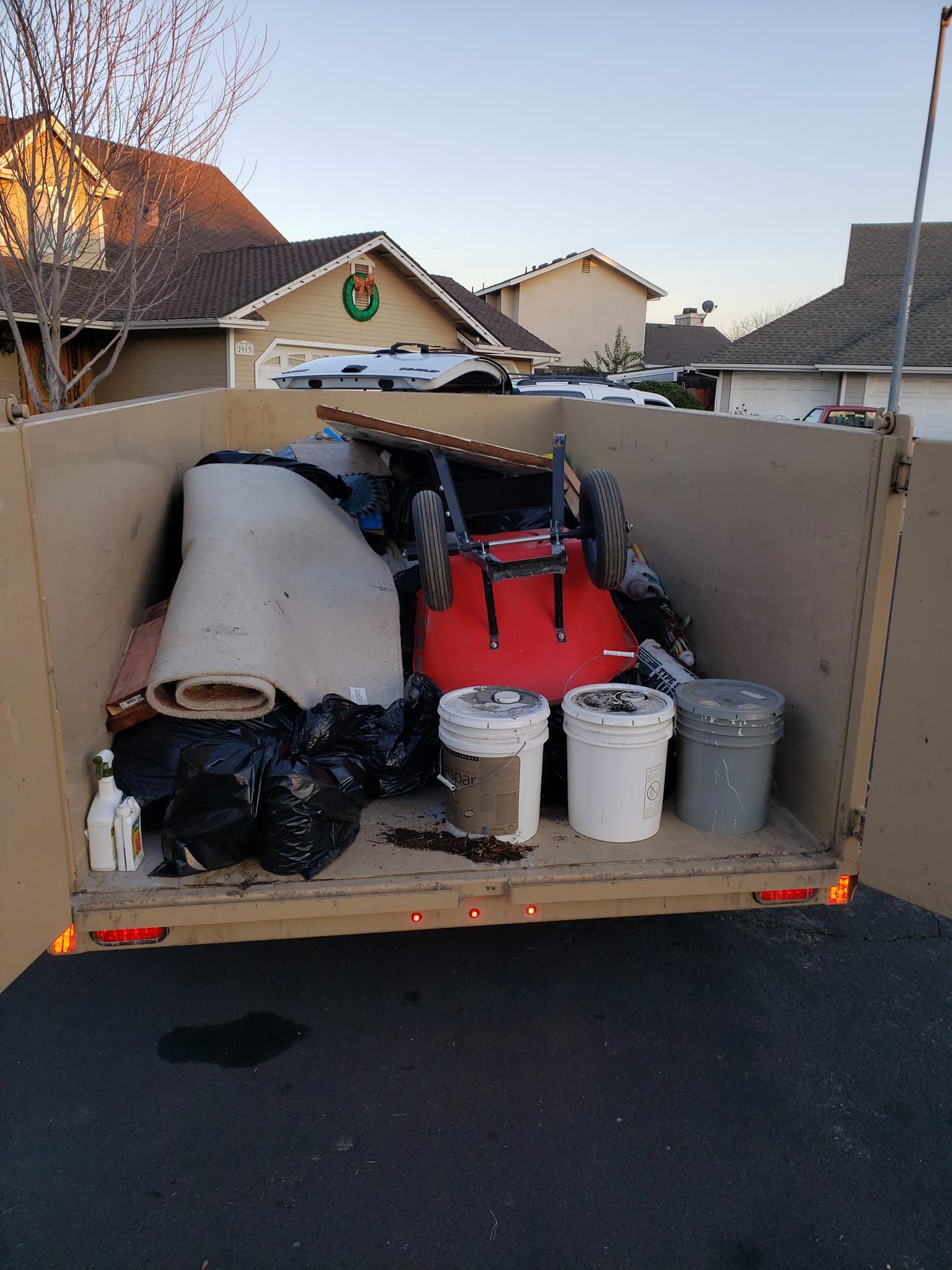 A cardboard box filled with buckets and a lawn mower
