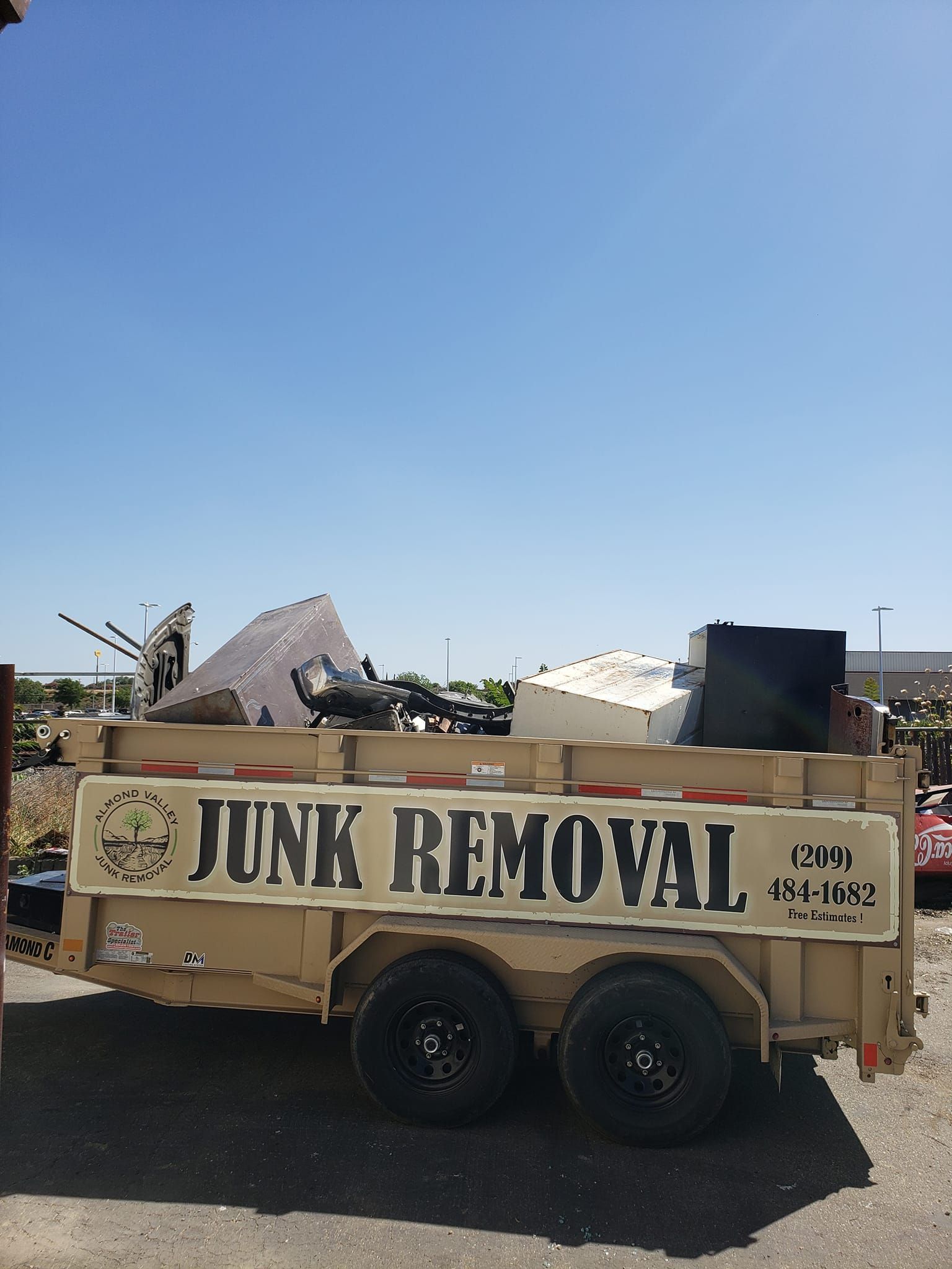 A junk removal trailer is parked on the side of the road