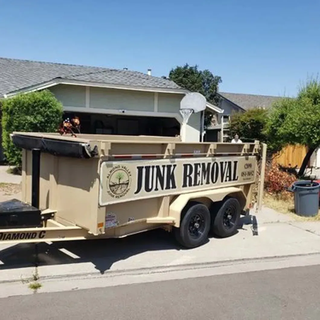 A junk removal trailer is parked in front of a house