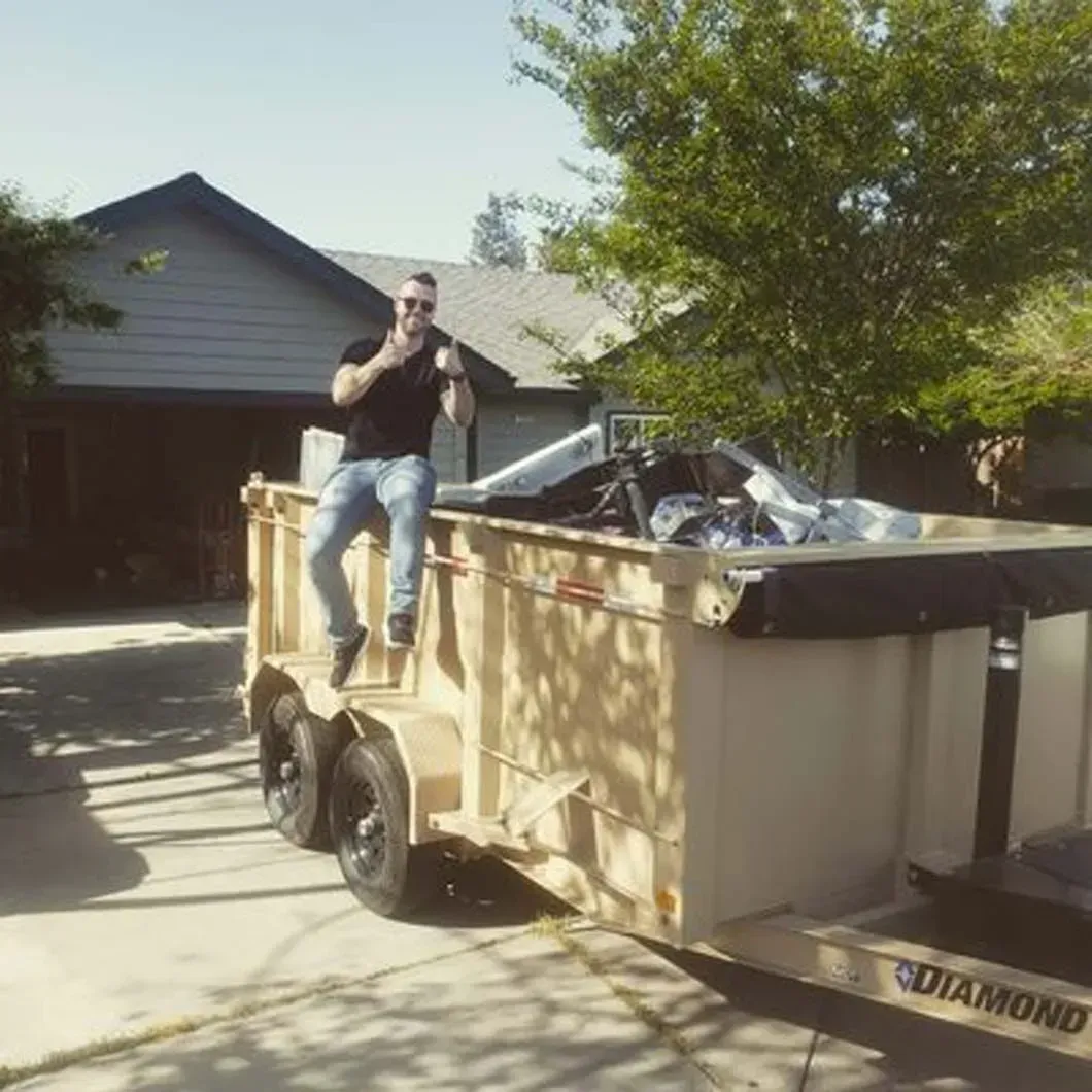 A man is sitting on top of a dumpster that says diamond