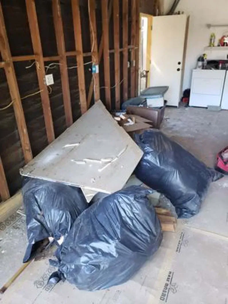 A bunch of trash bags are sitting on the floor in a room.