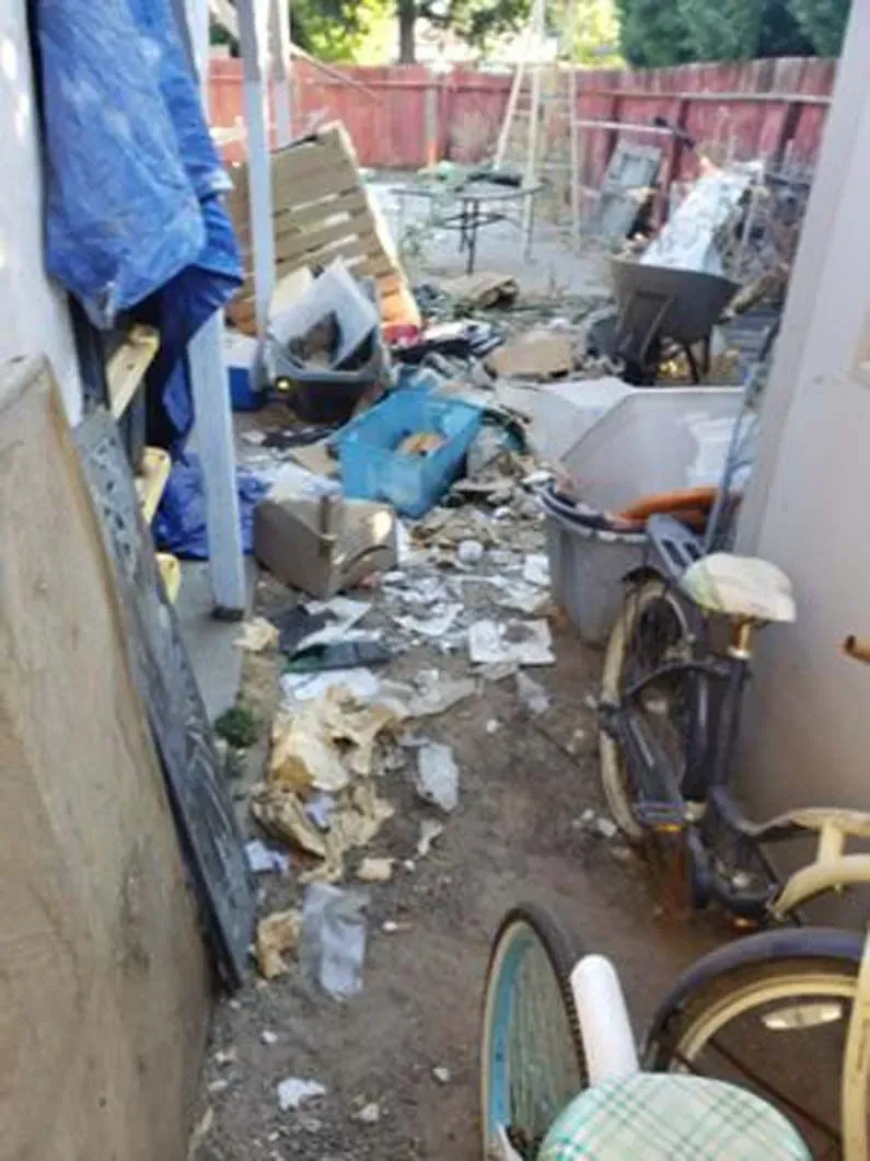 A bicycle is parked in a messy yard