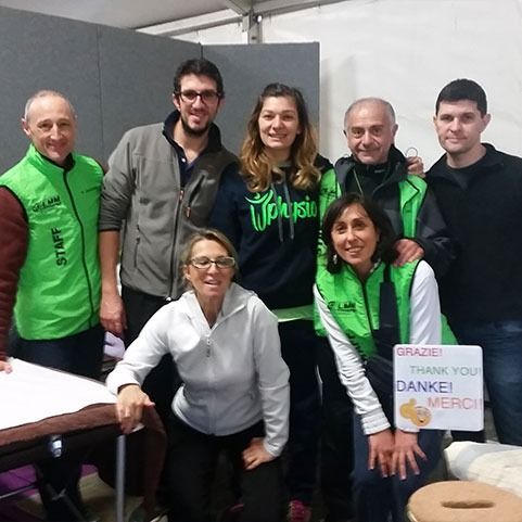 Gruppo di otto persone in posa, alcune con i gilet verdi. Tengono un cartello di ringraziamento.