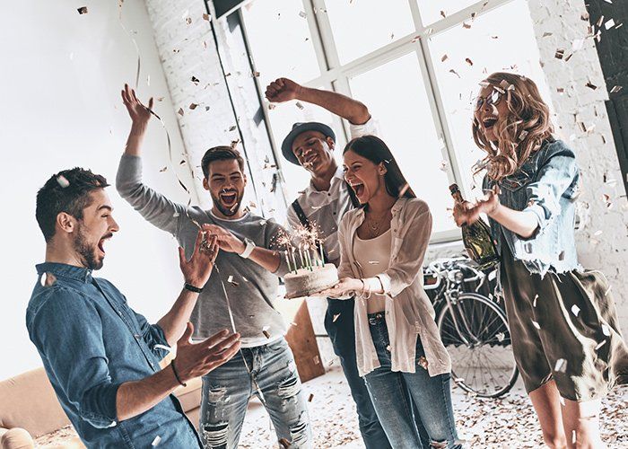 Graduation Parties — Happy Young Man Celebrating Birthday Among Friends In Redford, MI