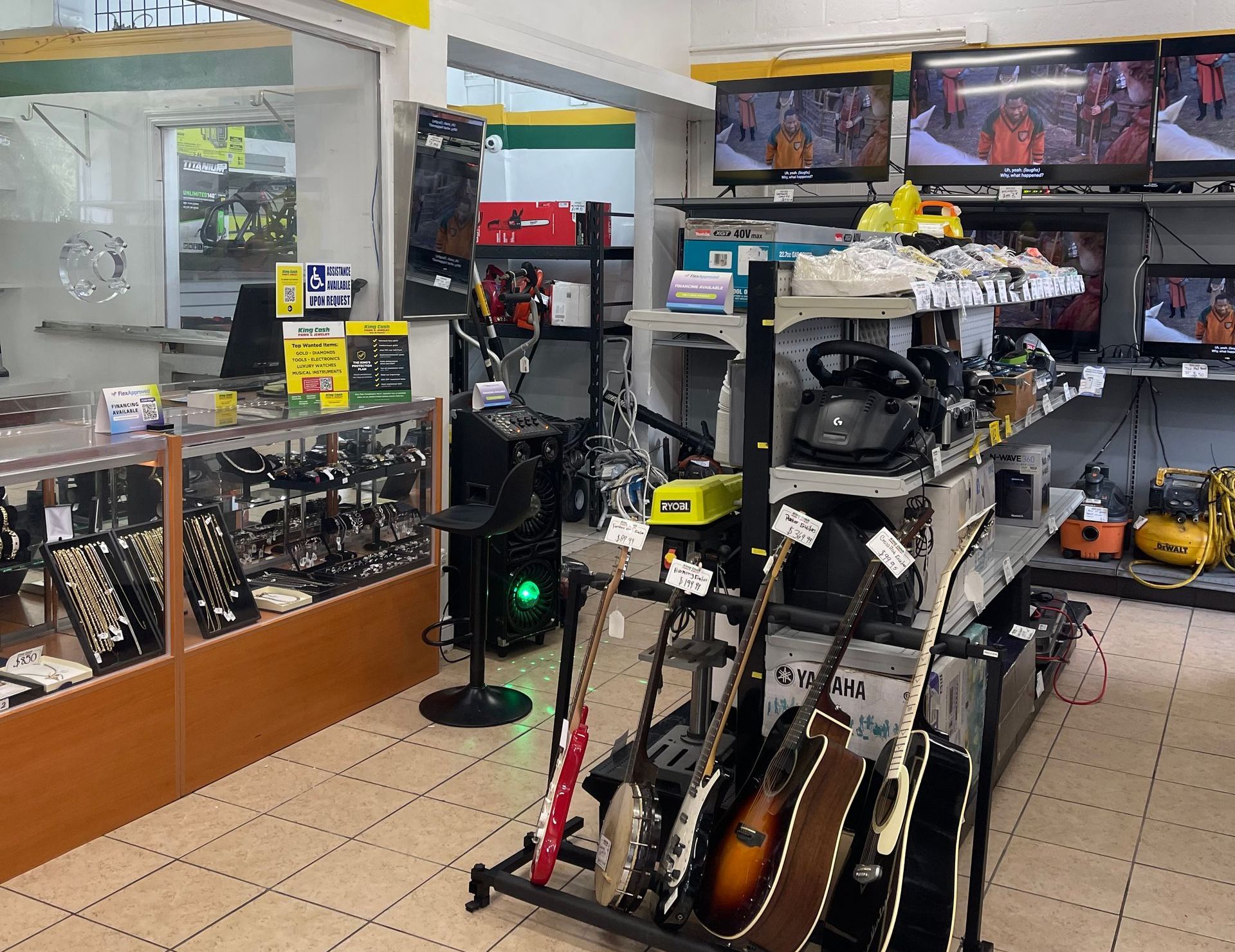 Interior view of King Cash Pawn & Jewelry store showcasing jewelry, musical instruments, electronics, and tools on display. 