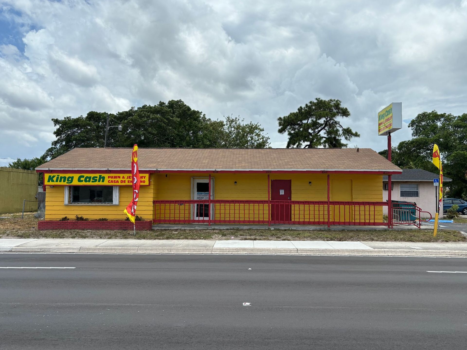 Exterior view of King Cash Pawn & Jewelry store in Opa Locka with a yellow building and