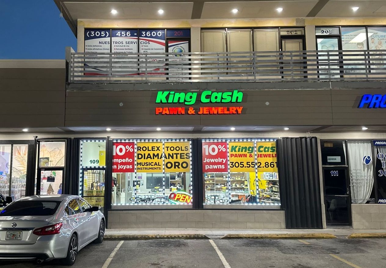 Exterior view of King Cash Pawn & Jewelry store in Sweetwater with illuminated signs of offerings.