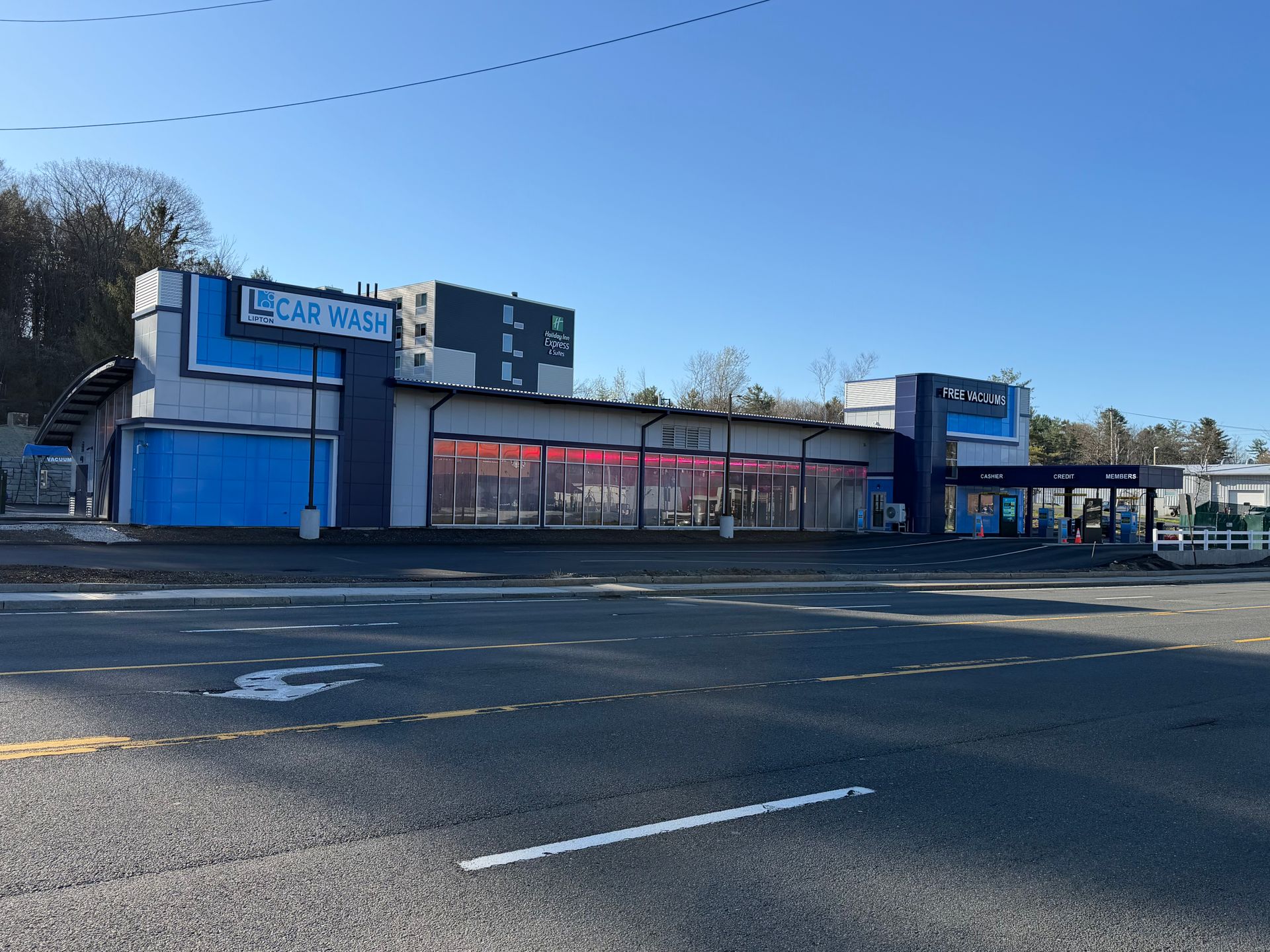 Hand washing soapy side window of a black car with a sponge.