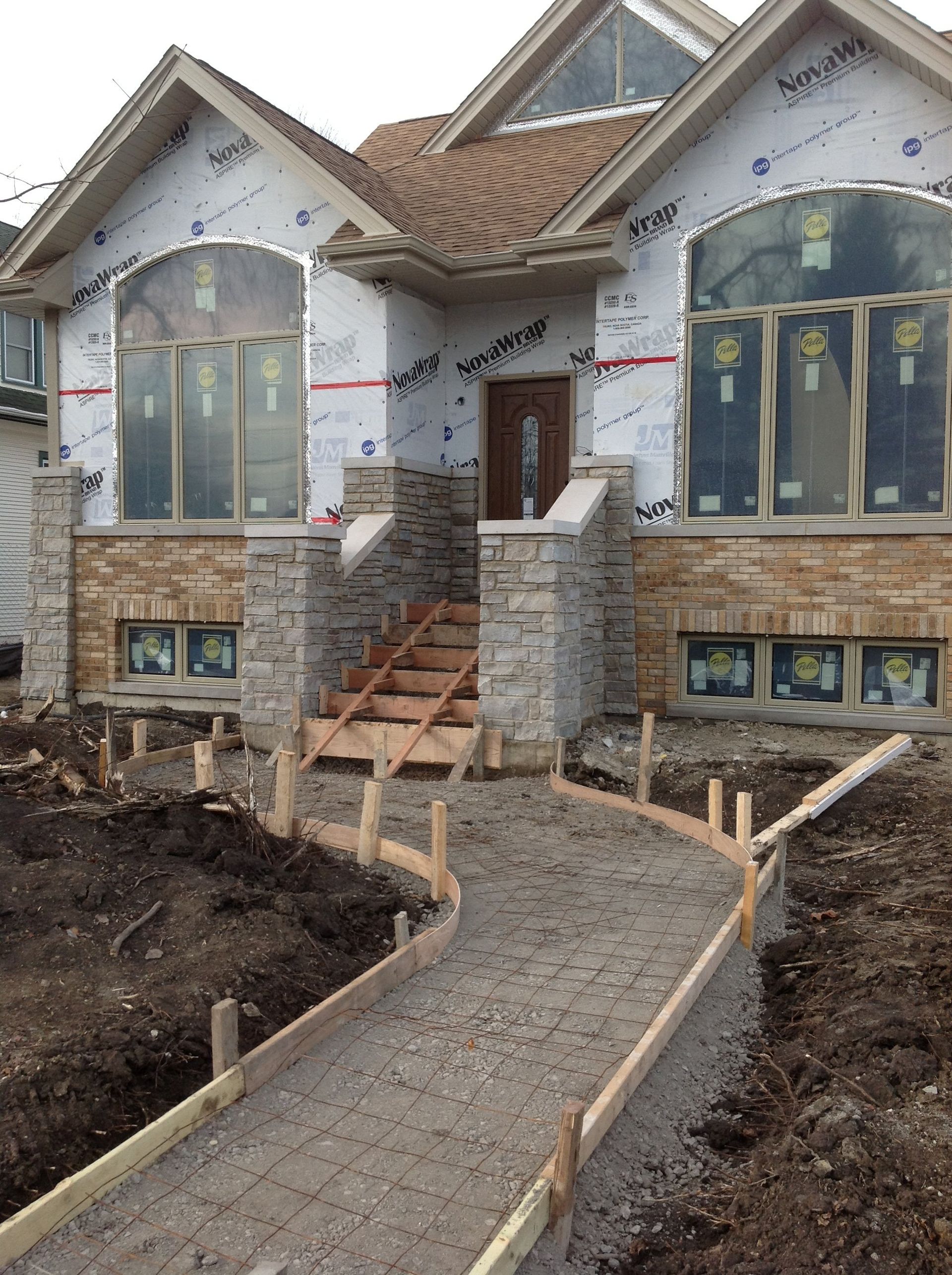 A house that is being built with a walkway in front of it