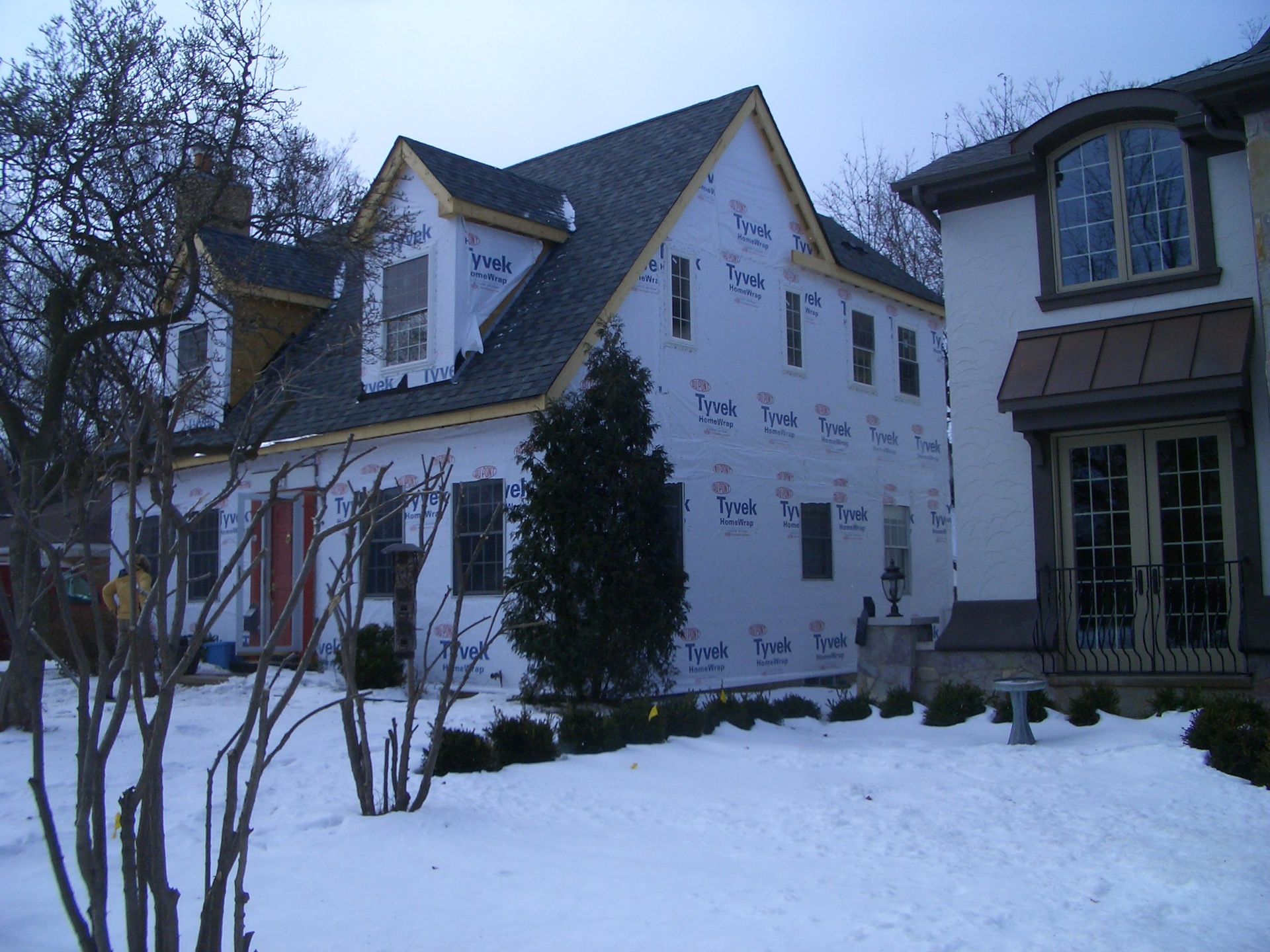 A large house with a lot of windows is covered in snow