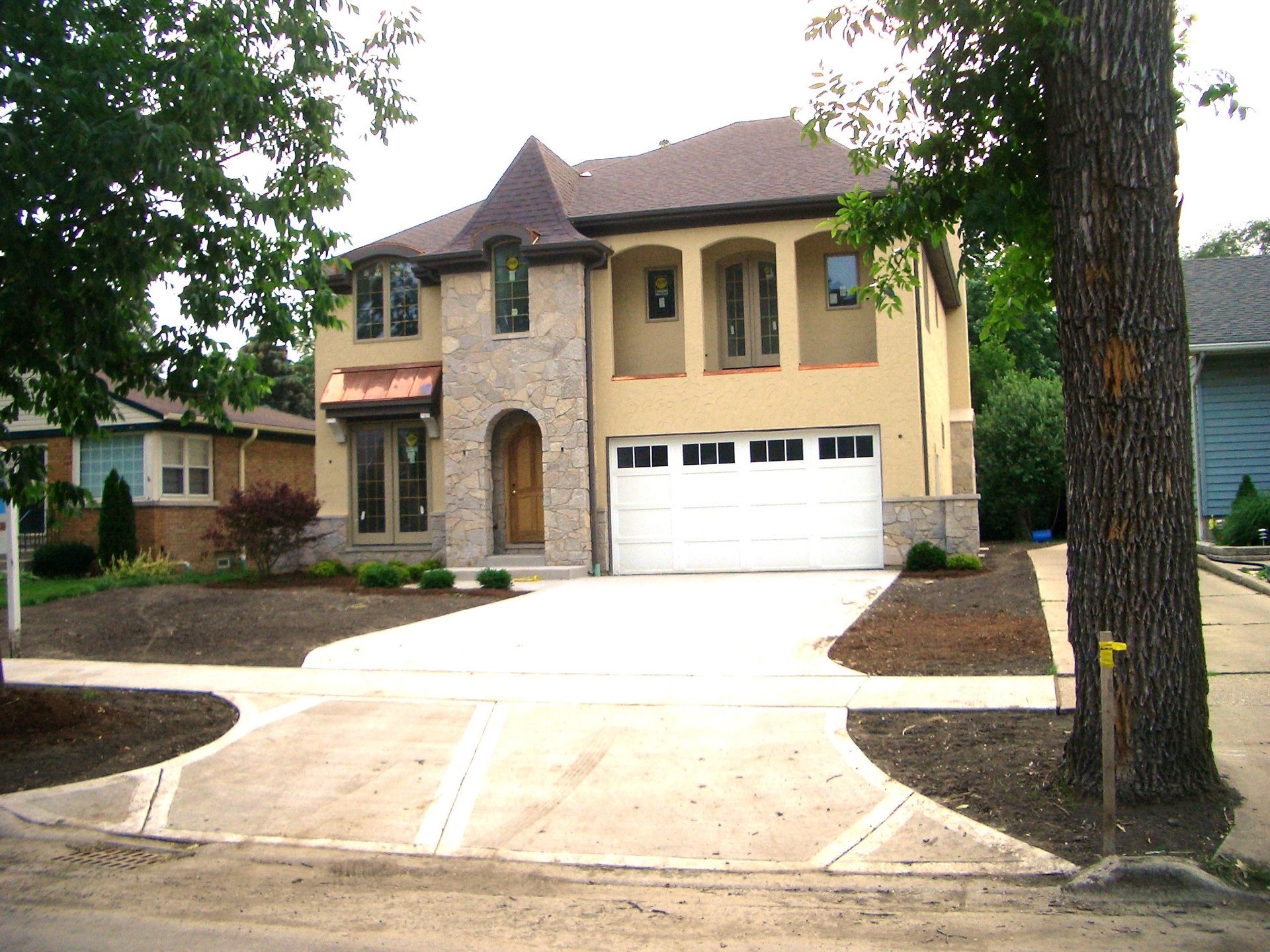A large yellow house with a white garage door