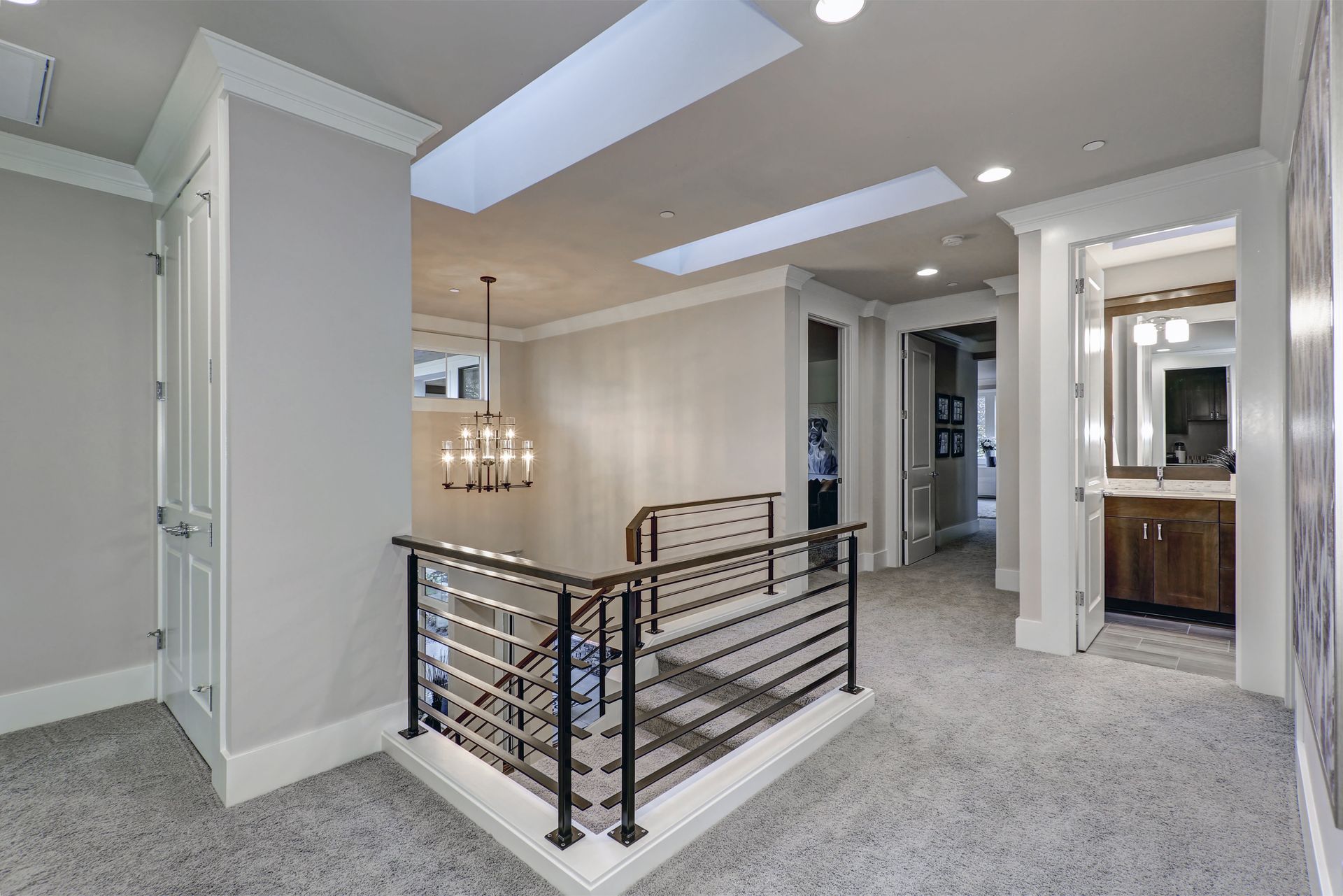 A hallway in a house with a balcony and a skylight.