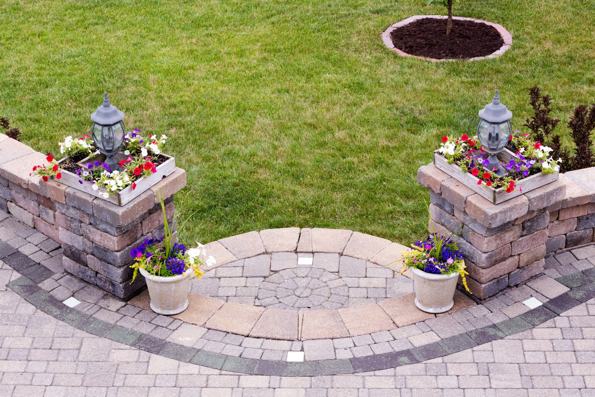 A couple of potted plants sitting on top of a brick walkway.