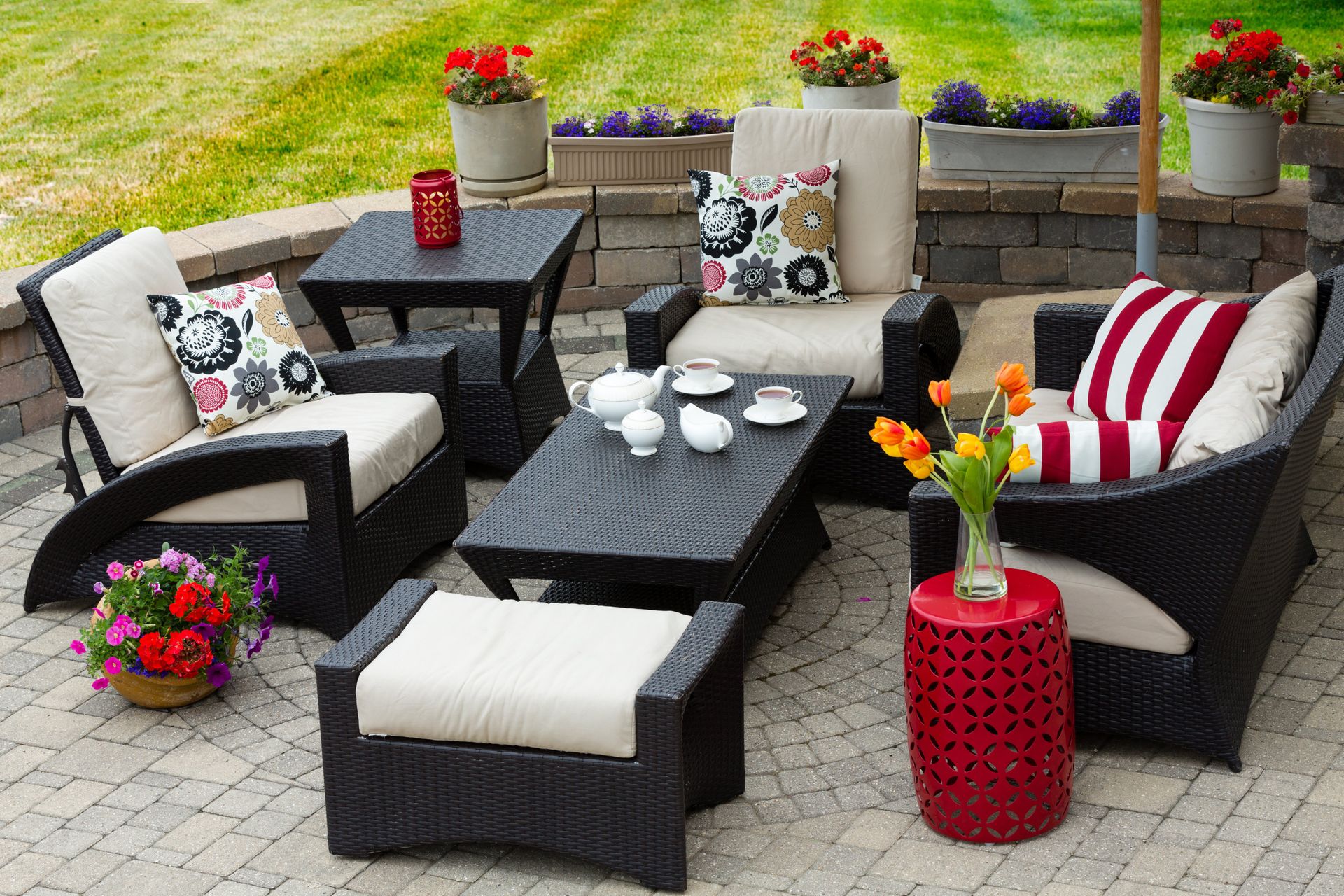 A patio with wicker furniture and flowers on it