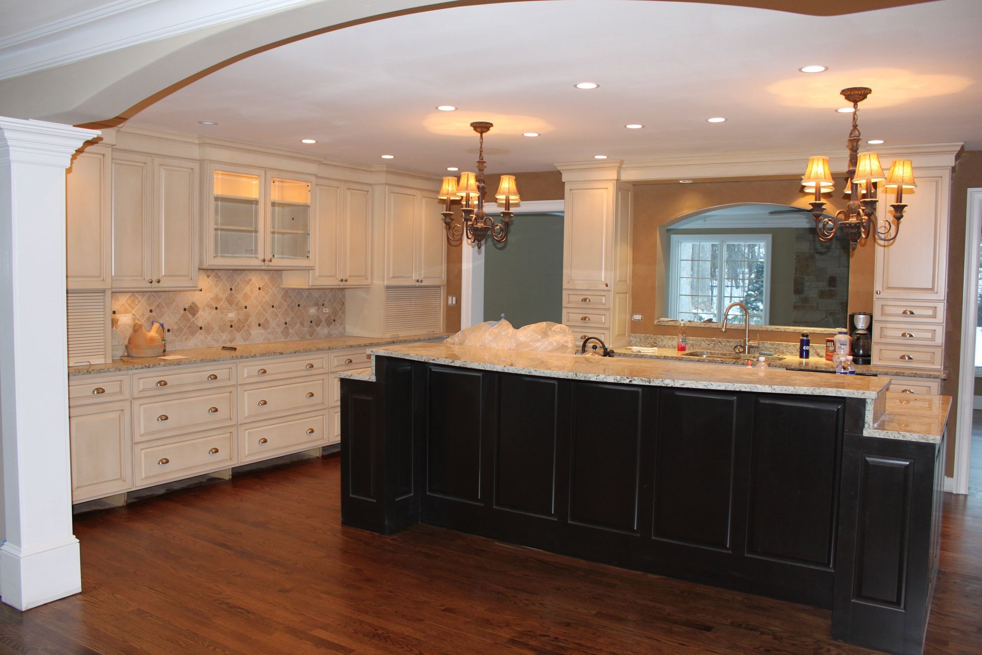 A large kitchen with white cabinets and a black island